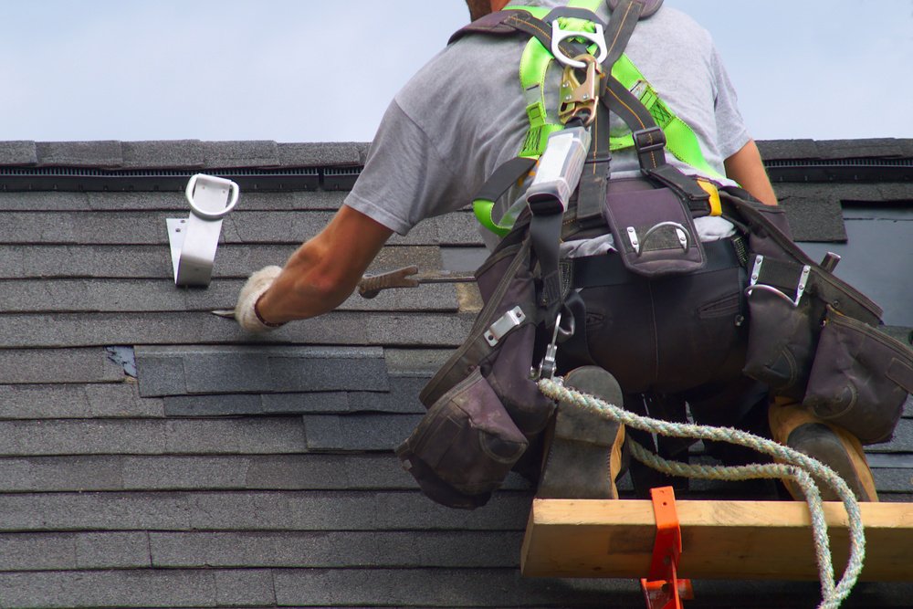 Roofer construction worker repairing a roof